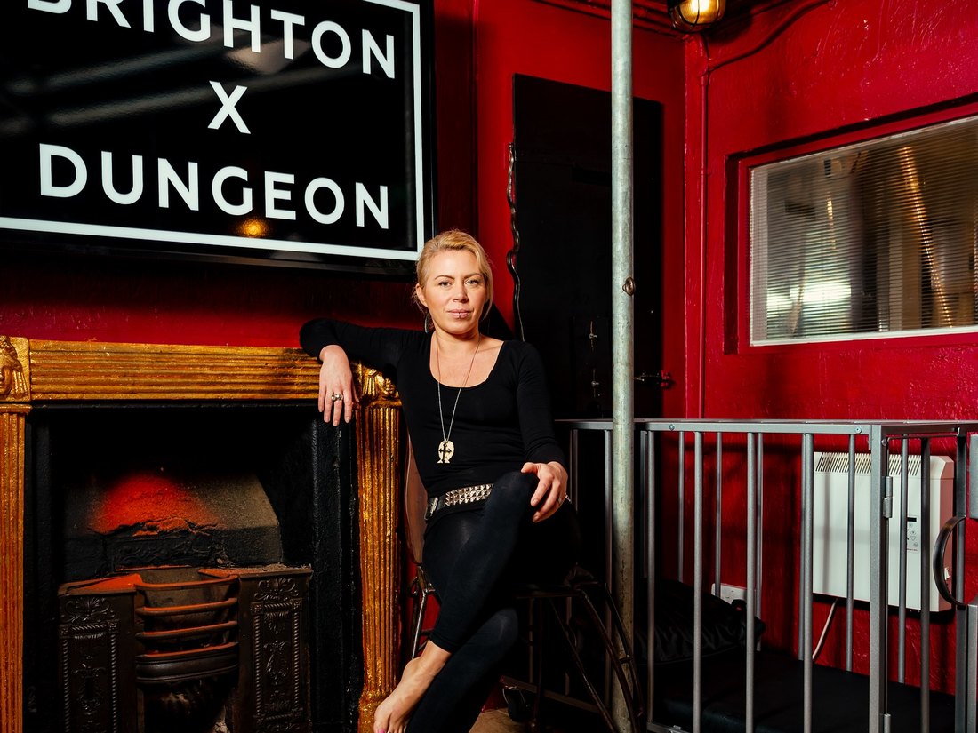 Calandra Balfour in Brighton Dungeon, under the Brighton x Dungeon sign